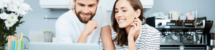 Couple smiling and looking at laptop