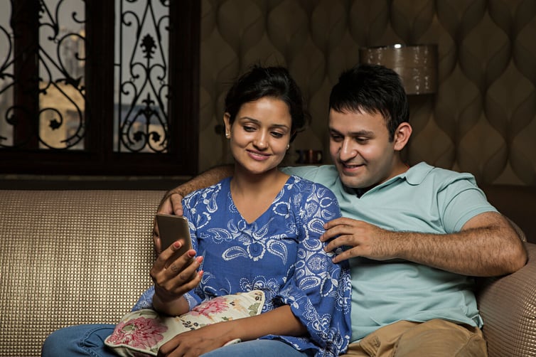 couple on the couch looking at their phone
