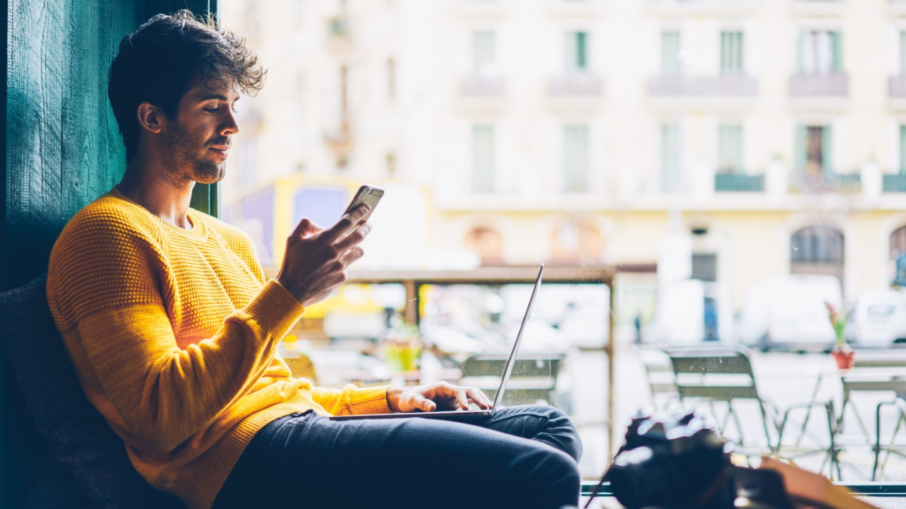 man yellow jumper on phone